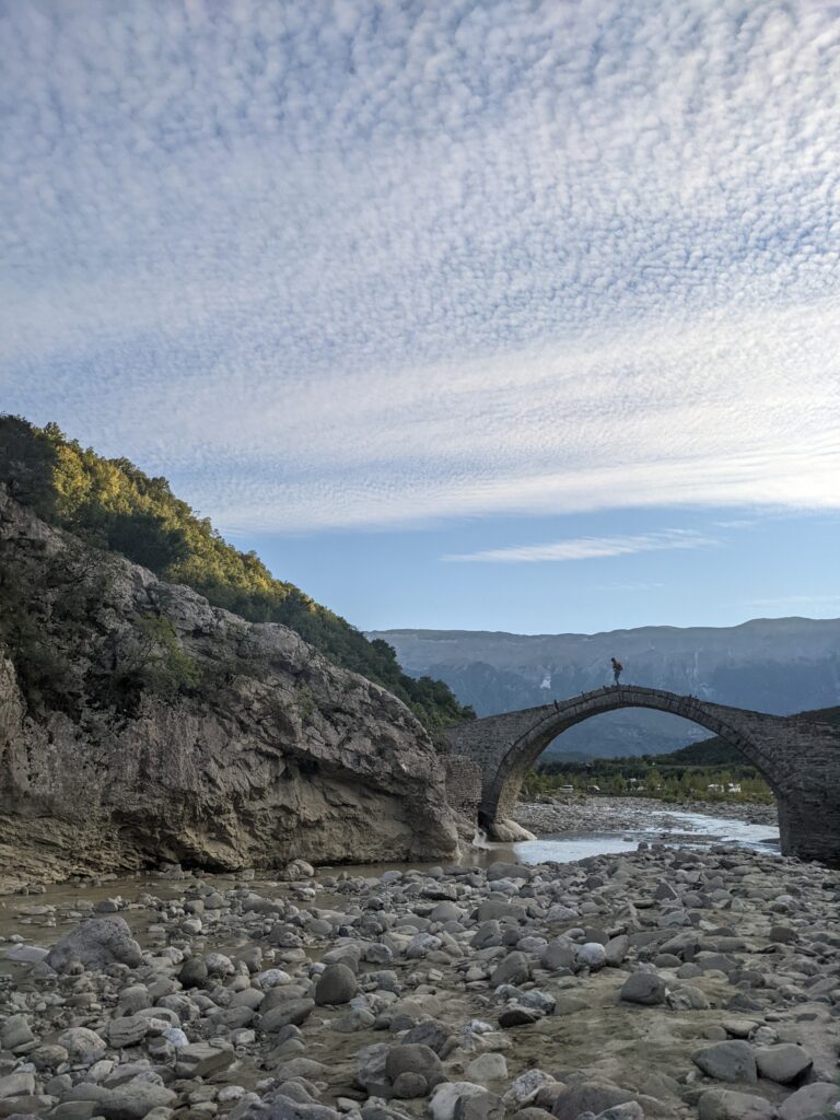 Pont traversant la rivière pour se rendre aux Sources chaudes de Bënjë, en Albanie, avec les montagnes en arrière plan
